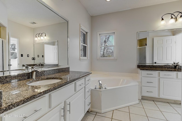 bathroom featuring tile patterned floors, vanity, and shower with separate bathtub