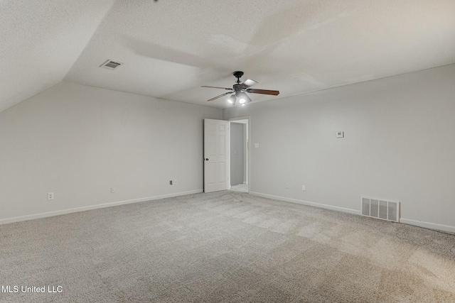 spare room featuring a textured ceiling, ceiling fan, lofted ceiling, and carpet floors