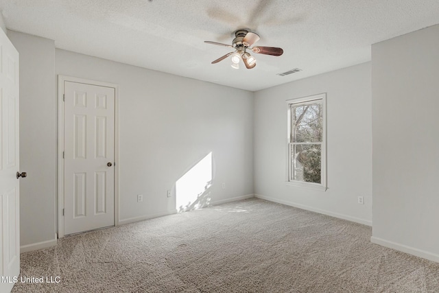 carpeted spare room with a textured ceiling and ceiling fan