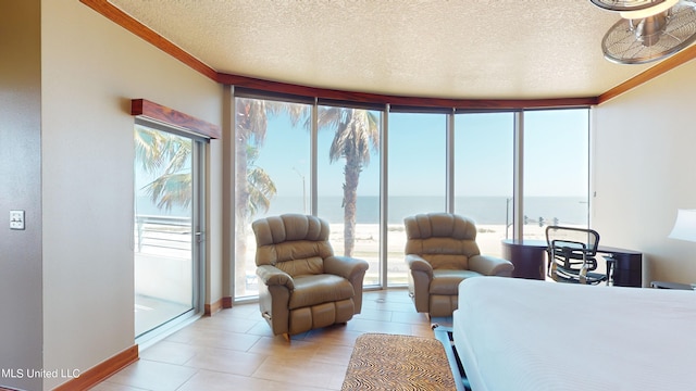 bedroom featuring ornamental molding, a water view, light tile patterned floors, expansive windows, and a textured ceiling