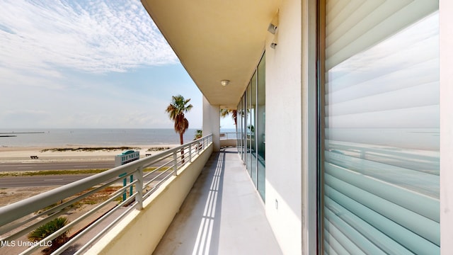 balcony featuring a water view and a beach view