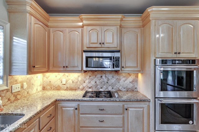 kitchen featuring light brown cabinetry, appliances with stainless steel finishes, a healthy amount of sunlight, and tasteful backsplash