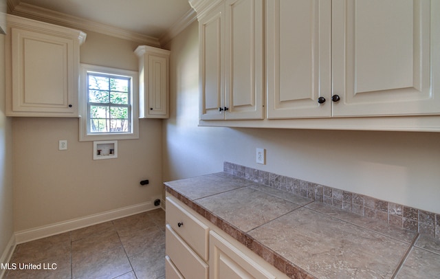 laundry area featuring ornamental molding, hookup for a washing machine, light tile patterned floors, and cabinets