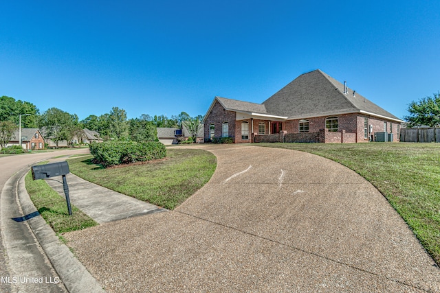 view of front of home featuring a front yard and central AC