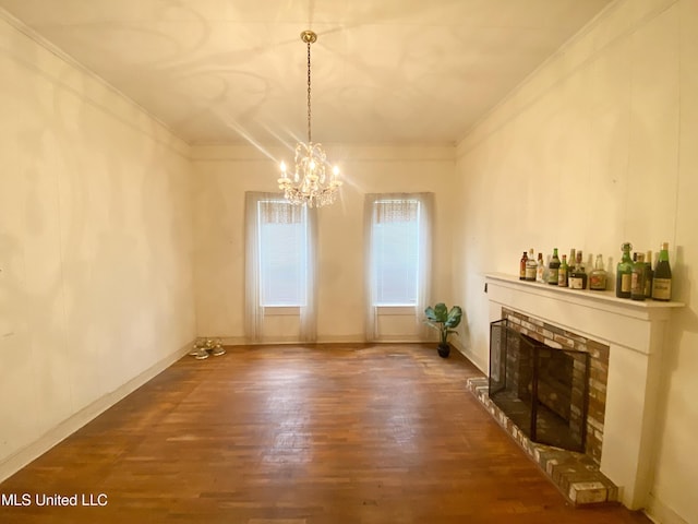 613 Georgetown St, Hazlehurst, MS 39083 - unfurnished dining area featuring wood finished floors, crown molding, a chandelier, and a fireplace with raised hearth