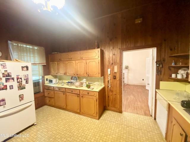 613 Georgetown St, Hazlehurst, MS 39083 - kitchen featuring freestanding refrigerator, light countertops, wood walls, a chandelier, and light floors