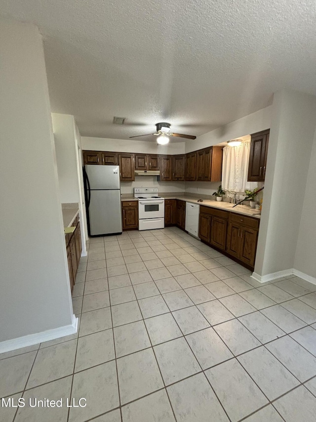 kitchen featuring white appliances, a textured ceiling, sink, ceiling fan, and light tile patterned floors