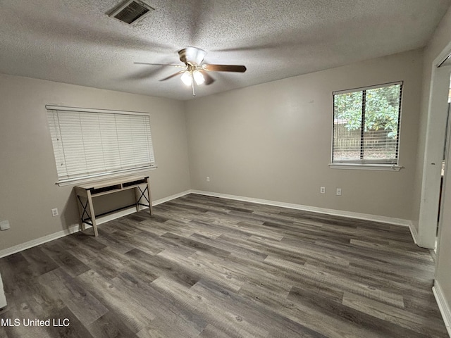 unfurnished bedroom with a textured ceiling, visible vents, baseboards, a ceiling fan, and wood finished floors