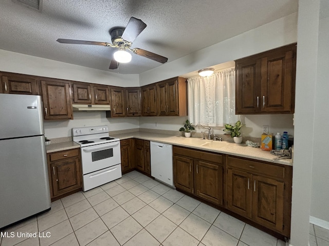 kitchen featuring ceiling fan, sink, white appliances, a textured ceiling, and light tile patterned floors