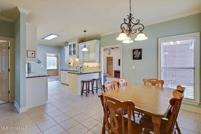 dining space featuring ornamental molding, light tile patterned flooring, and baseboards