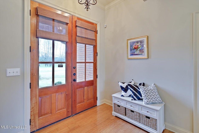 entrance foyer featuring light wood finished floors, baseboards, french doors, and ornamental molding