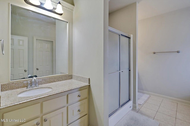 bathroom with baseboards, a shower stall, vanity, and tile patterned floors