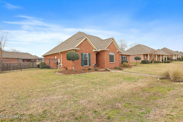 view of front of house featuring a front yard, fence, and brick siding