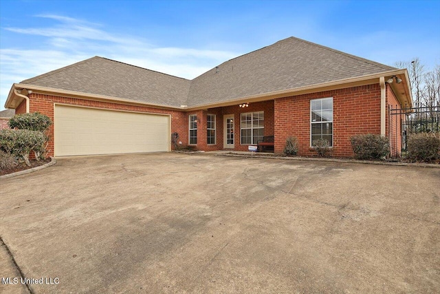 view of front facade featuring a shingled roof, brick siding, driveway, and a garage