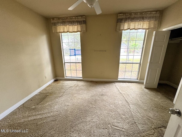 empty room featuring ceiling fan and carpet flooring