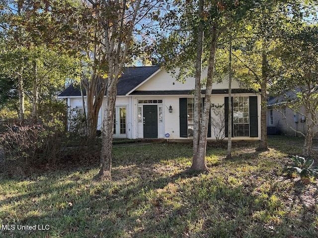 view of front of home with central AC unit and a front lawn