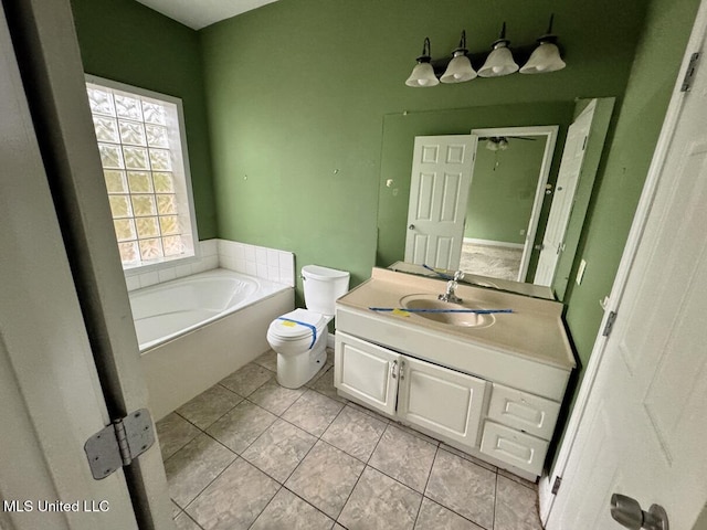 bathroom featuring tile patterned flooring, a bathing tub, vanity, and toilet