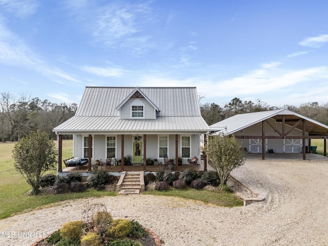 view of front of house featuring driveway, covered porch, metal roof, and a carport