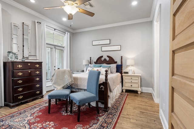 bedroom with ceiling fan, visible vents, baseboards, light wood finished floors, and crown molding