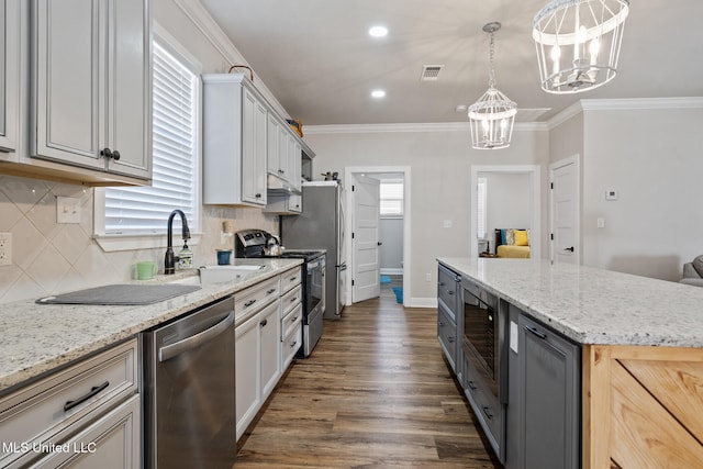 kitchen with stainless steel appliances, a kitchen island, hanging light fixtures, gray cabinets, and crown molding