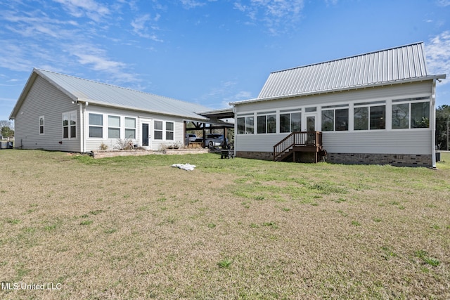 rear view of house with crawl space, an attached carport, metal roof, and a lawn