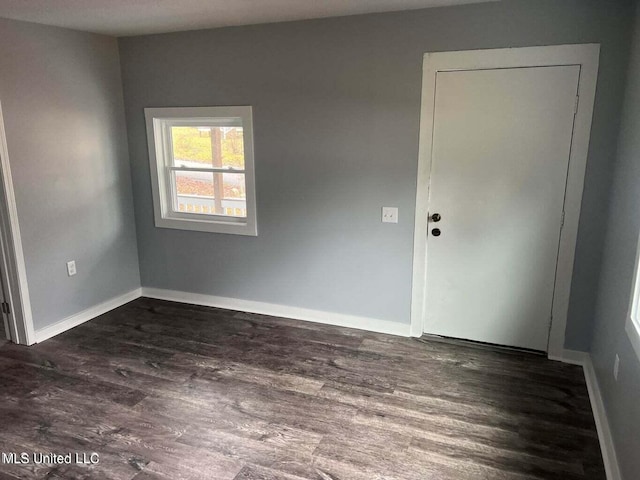 unfurnished room with dark wood-type flooring