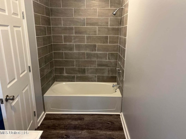 bathroom featuring tiled shower / bath combo and wood-type flooring