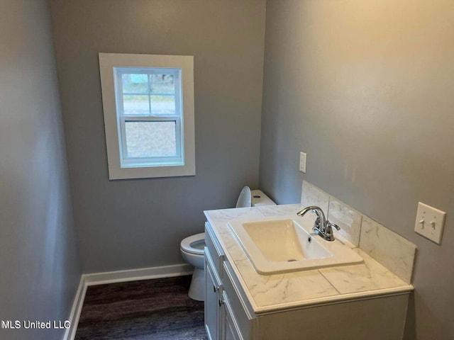 bathroom with vanity, toilet, and wood-type flooring