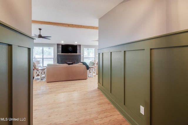 hall with light wood-style flooring, beamed ceiling, and recessed lighting