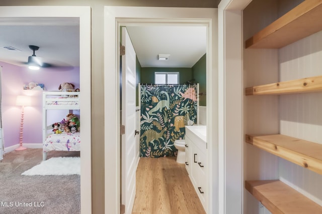 full bath featuring toilet, wood finished floors, vanity, curtained shower, and ceiling fan