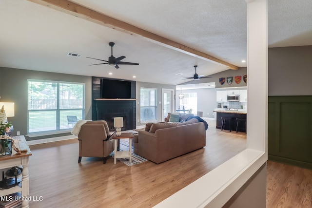 living room with a large fireplace, ceiling fan, light wood-style floors, and recessed lighting