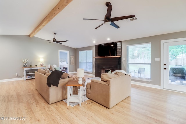 living room with a fireplace, light wood-style flooring, a ceiling fan, and baseboards