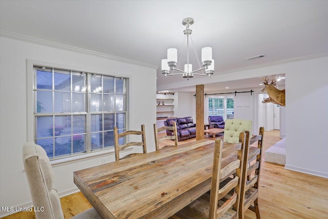 102 Holly Trl, Brandon, MS 39047 - dining room with a chandelier, crown molding, a barn door, light wood-style floors, and baseboards
