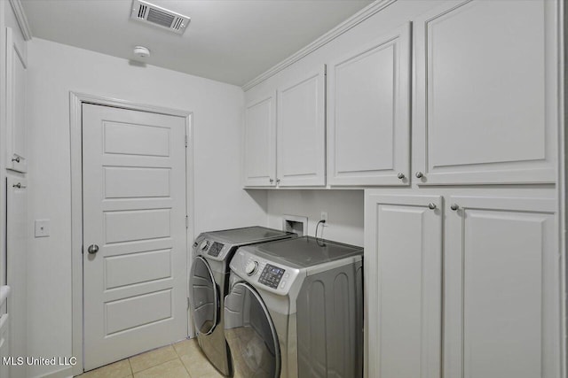 102 Holly Trl, Brandon, MS 39047 - laundry area with washer and dryer, cabinet space, and light tile patterned floors