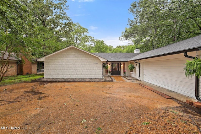 102 Holly Trl, Brandon, MS 39047 - rear view of property with an attached garage, brick siding, a chimney, and concrete driveway