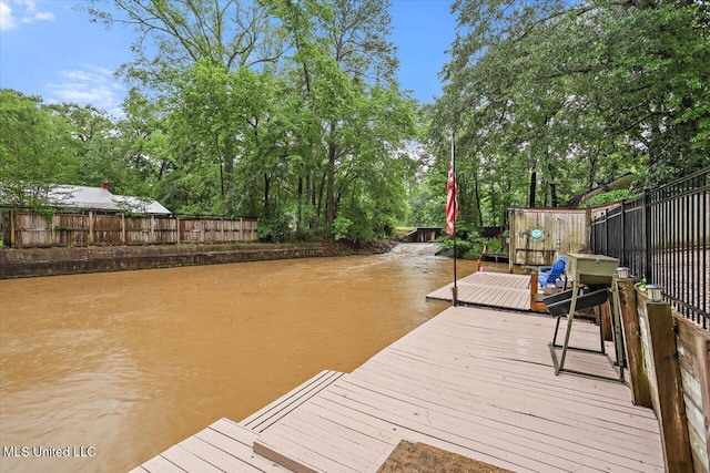 102 Holly Trl, Brandon, MS 39047 - dock area with a fenced backyard, a deck with water view, and view of wooded area