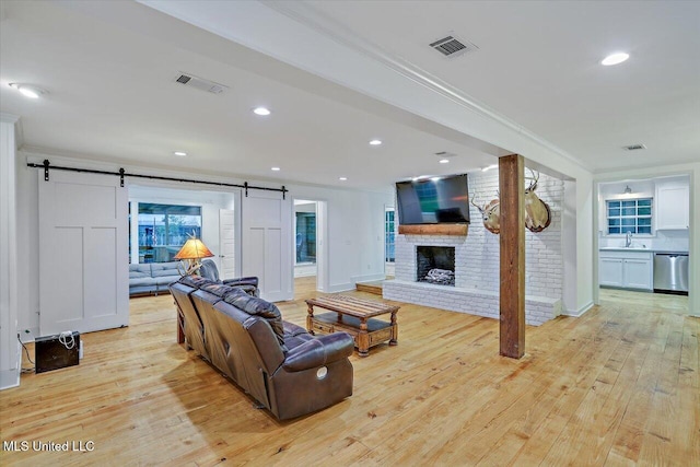 102 Holly Trl, Brandon, MS 39047 - living room featuring a barn door, light wood finished floors, ornamental molding, recessed lighting, and baseboards