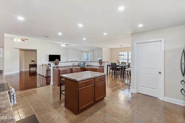 7637 Wisteria Dr, Olive Branch, MS 38654 - kitchen featuring recessed lighting, a breakfast bar area, a ceiling fan, and a spacious island