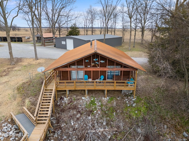 back of house with a garage and a rural view