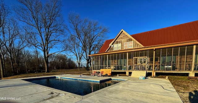 view of swimming pool with a patio area and a sunroom