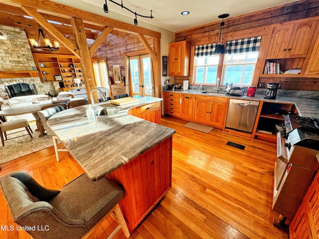 kitchen featuring french doors, sink, light wood-type flooring, pendant lighting, and stainless steel appliances