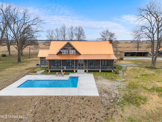 back of property featuring a patio area, a sunroom, and a lawn