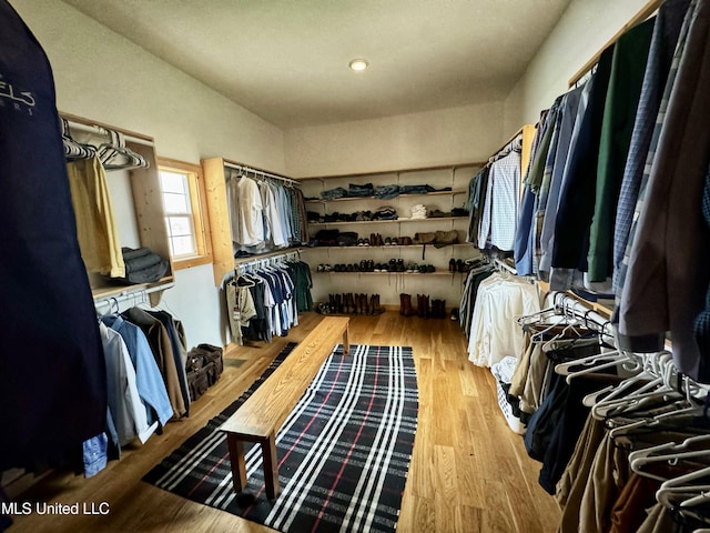 walk in closet with light hardwood / wood-style flooring