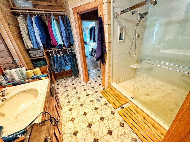 bathroom with vanity, wood walls, and walk in shower