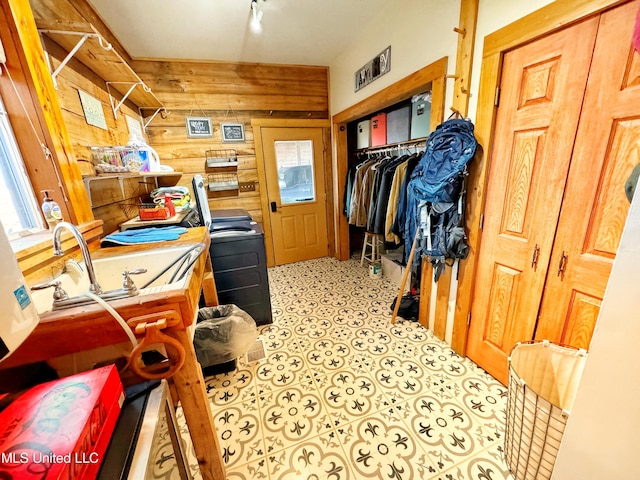 laundry room with washer / dryer, sink, and wooden walls