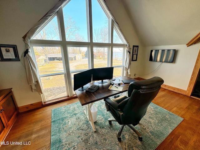 home office with wood-type flooring and high vaulted ceiling