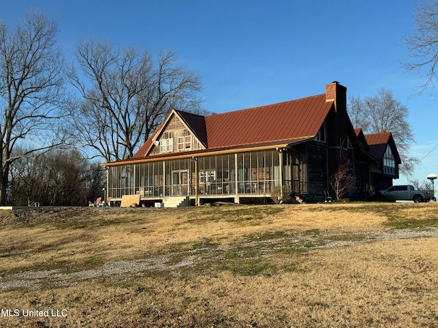 view of front of house featuring a sunroom and a front yard