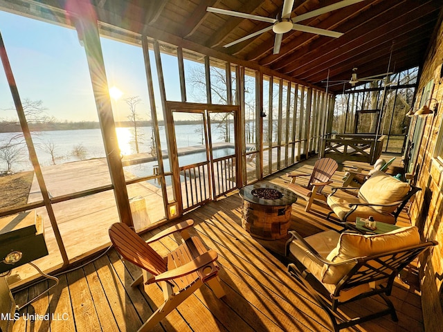 sunroom / solarium featuring a water view and ceiling fan