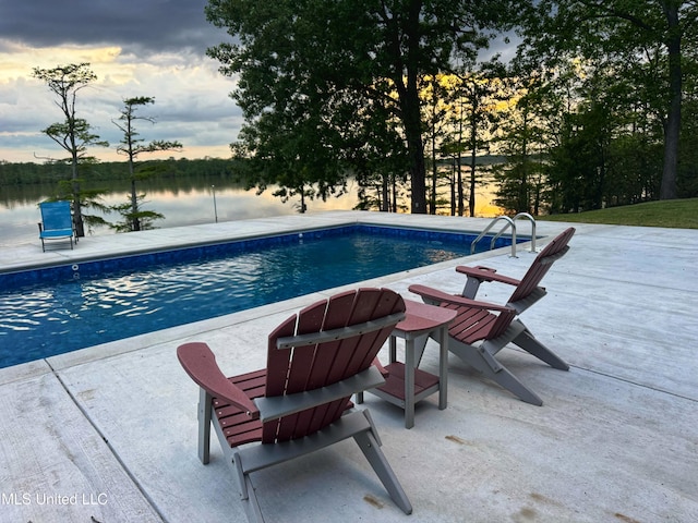 swimming pool featuring a water view and a patio area