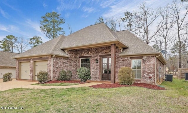 view of front of property with a garage, central AC unit, and a front lawn